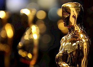 The image shows several golden Oscar statuettes, which are awarded as trophies for excellence in the film industry.