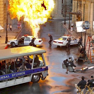 A movie set scene with an explosion, a tram labeled 